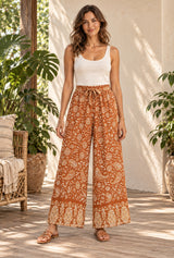 Boho Wide Leg Pants – “Saffron Meadow” Rust Floral Drawstring Palazzo Pants — styled on an AI-generated model