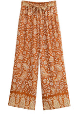 Rust-orange wide-leg palazzo pants with cream floral print, drawstring waist and patterned hems